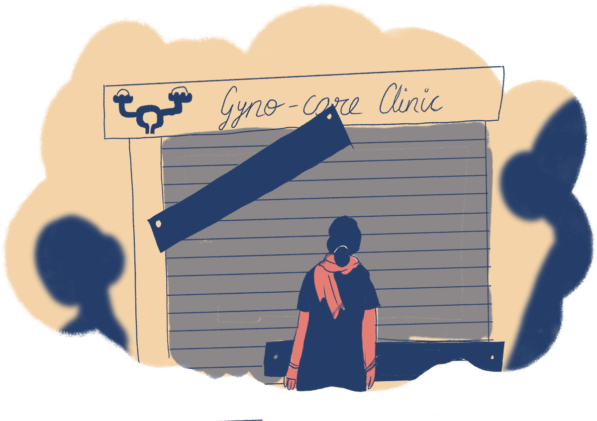 A woman is standing in front of a gynaecology clinic. The shutters are closed and there are wooden planks nailed on it. There is a sign on top which says 